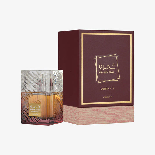 Lattafa Khamrah Dukhan perfume bottle next to its matching burgundy display box.